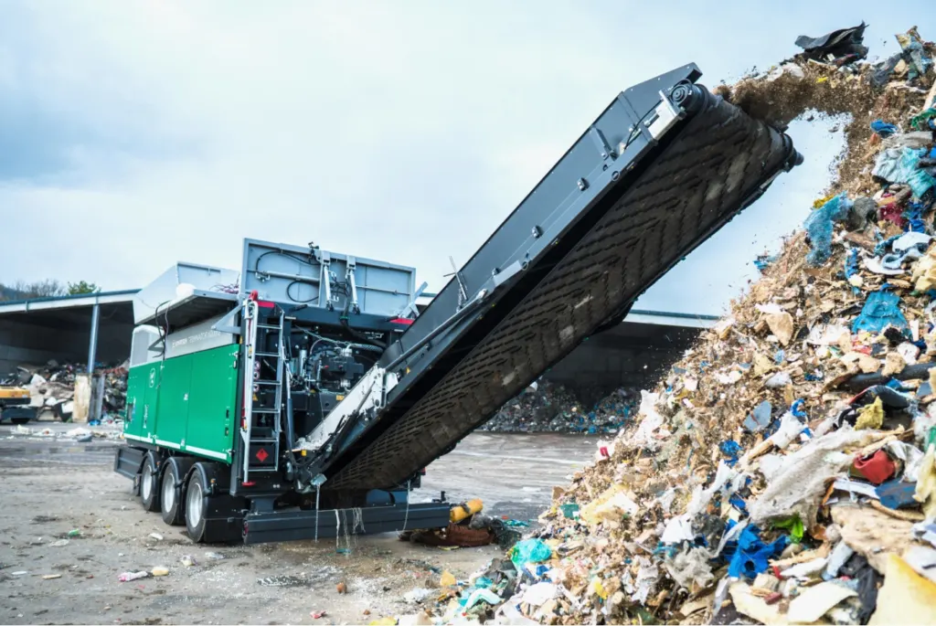 „Terminator“ in Aktion: Die Maschine zerkleinert gemischte Abfälle und transportiert das aufbereitete Material über das Austragsband zur weiteren Verwertung. In Cesano werden künftig drei stationäre „Terminator“ eingesetzt. (Foto: Komptech)